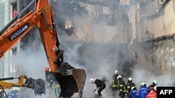 Rescuers work on the rubble of a damaged residential building in Uman, Ukraine, on April 28, 2023, after Russian missile strikes targeted several Ukrainian cities overnight.