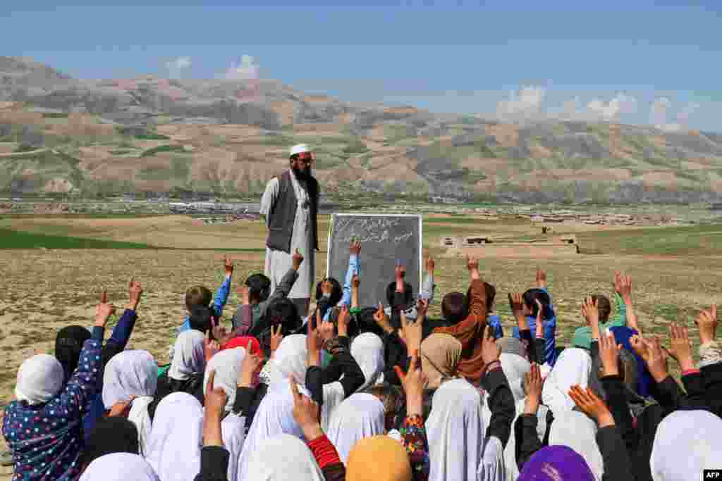 Afghan children attend a class at an open air school on the outskirts of Fayzabad district, Badakhshan province.