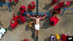 Ruben Enaje is nailed to the cross during a reenactment of Jesus Christ's sufferings as part of Good Friday rituals, in the village of San Pedro, Cutud, Pampanga province, northern Philippines, April 7, 2023.