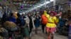 Seorang pedagang tampil mengenakan kostum di dekat penjual kentang dalam perayaan Hari Kentang Internasional di salah satu pasar di Lima, Peru, pada 30 Mei 2024. (Foto: AP/Martin Mejia)
