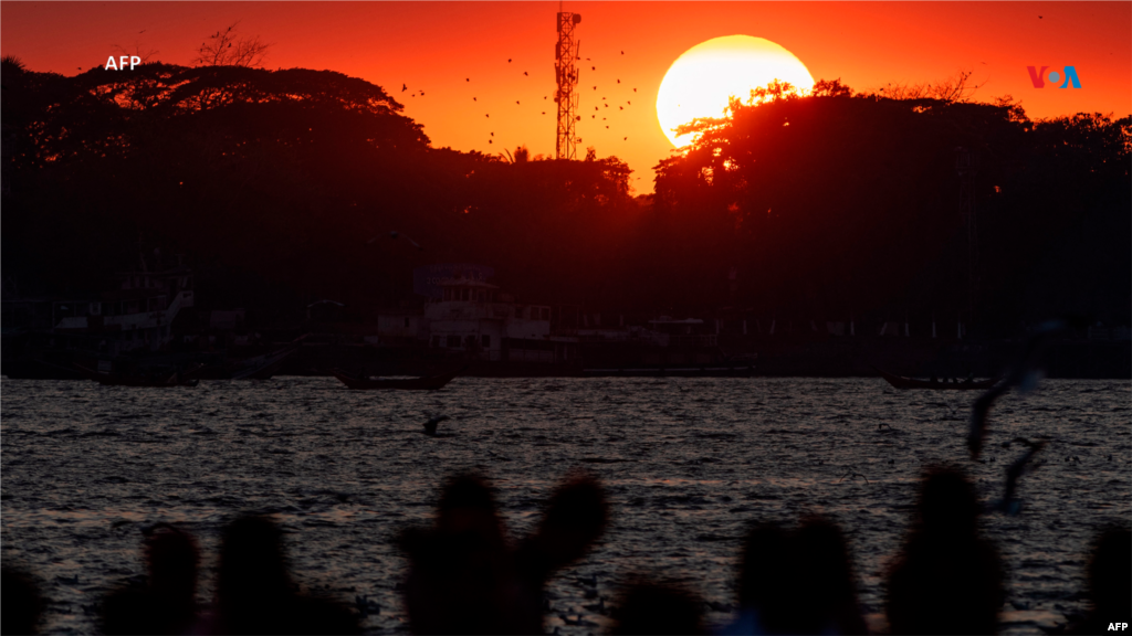 Desde Myanmar: La gente se reúne para observar la última puesta de sol del año en el embarcadero de Botahtaung, en el río Yangon, el 31 de diciembre de 2023.