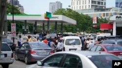 People queue to buy fuel at the Nigerian National Petroleum Company Limited petrol station in Lagos, Nigeria, Tuesday, May 30, 2023.
