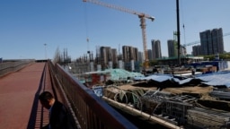 一名男子坐在北京一处建筑工地旁。（2023年4月18日）