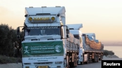 Rombongan truk asal Arab Saudi, yang membawa bantuan untuk korban gempa Turki-Suriah, bergerak melewati wilayah perlintasan al-Hamam di Afrin, Suriah, pada 11 Februari 2023. (Foto: Reuters/Mahmoud Hassano)