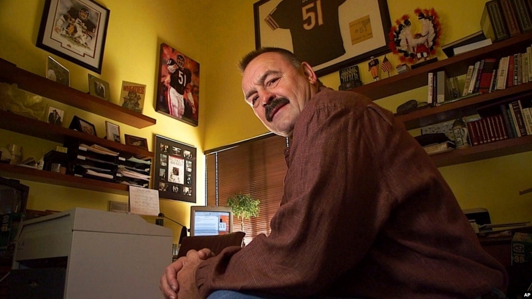 FILE - Former Chicago Bears linebacker Dick Butkus is surrounded by football memorabilia at his home in Malibu, Calif., Jan. 6, 2000. Butkus died Oct. 5, 2023, at his home. He was 80.