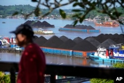 Coal barges are anchored on Mahakam River in Samarinda, East Kalimantan, Indonesia, Monday, Dec. 19, 2022. (AP Photo/Dita Alangkara)