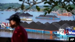 Tongkang batu bara berlabuh di Sungai Mahakam di Samarinda, Kalimantan Timur, Senin, 19 Desember 2022. (AP/Dita Alangkara)