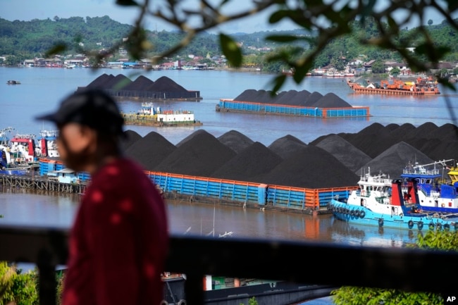 Coal barges are anchored on Mahakam River in Samarinda, East Kalimantan, Indonesia, Monday, Dec. 19, 2022. (AP Photo/Dita Alangkara)