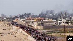 Warga Palestina menunggu truk bantuan menyeberang di tengah Jalur Gaza pada Minggu, 19 Mei 2024. (AP Photo/Abdel Kareem Hana)