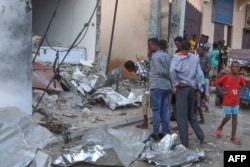 FILE - Residents pause to assess the damages at the site of an attack at the Pearl Beach Hotel in Mogadishu, on June 10, 2023.