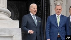 FILE - President Joe Biden talks with House Speaker Kevin McCarthy, as he departs the Capitol in Washington, March 17, 2023. Biden next week will meet with the Democratic and Republican leaders of the House and Senate in an effort to avoid a default on the nation's debts.