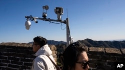 北京长城上安装的监控摄像头与游客。（2023年10月20日）