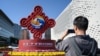 A man takes photos of an installation of the Belt and Road Forum in Beijing on Oct. 16, 2023.