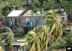 Family members begin to repair their home damaged in the passing of Hurricane Beryl, in Ottley Hall, St. Vincent and the Grenadines, July 2, 2024.