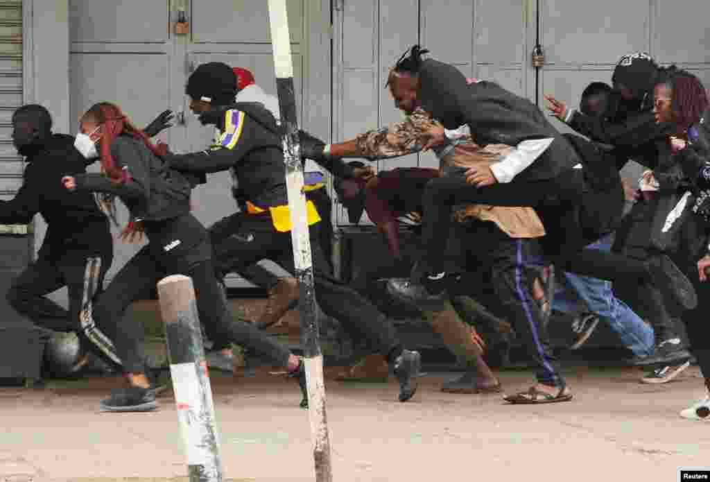 People run after police officers used teargas to disperse protesters during a demonstration over police killings of people protesting against Kenya&#39;s proposed finance bill 2024/2025, in Nairobi.