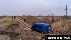 Aid workers navigate a broken road near Pravdne, Ukraine on Jan. 26, 2023