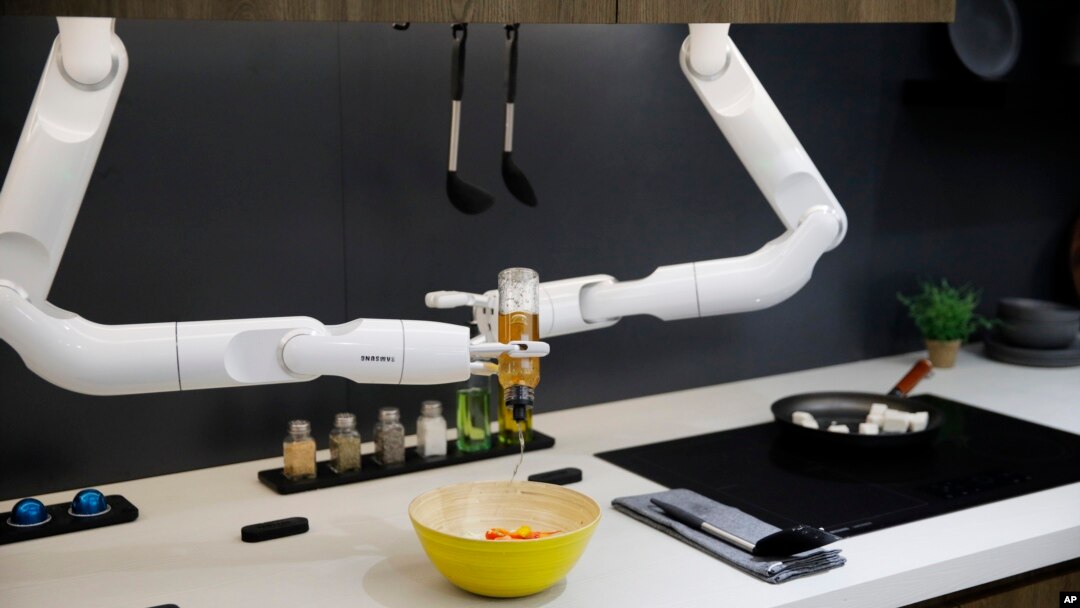 Bot Chef menuangkan saus ke dalam salad selama demonstrasi di samping kompor listrik yang dipajang di stan Samsung selama pameran teknologi CES di Las Vegas. (Foto: AP)
