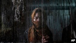 An Afghan woman makes a carpet at a traditional carpet factory in Kabul.