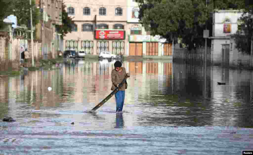 A boy plays on a flooded street following rains in Sanaa, Yemen.