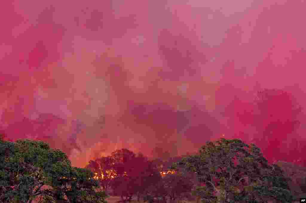 Fire retardant dropped from a plane drifts over the Aero Fire burning in the Copperopolis community of Calaveras County, California, June 17, 2024.