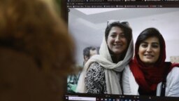 FILE - A woman looks at a computer screen with a photo of Iranian journalists Niloufar Hamedi, left, and Elaheh Mohammadi, right, in Nicosia, Cyprus, Nov. 2, 2022. 