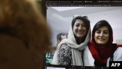 FILE - A woman looks at a computer screen showing Iranian journalists Niloufar Hamedi and Elaheh Mohammadi, in Nicosia, Cyprus, Nov. 2, 2022. 
