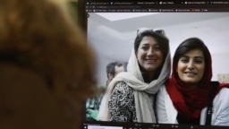FILE - A woman looks at a computer screen with a photo of Iranian journalists Niloufar Hamedi, left, and Elaheh Mohammadi, right, in Nicosia, Cyprus, Nov. 2, 2022. 