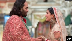 In this photo provided by Reliance Industries, Anant Ambani, son of billionaire Mukesh Ambani, holds hands with Radhika Merchant during their wedding ceremony at Jio World Convention Centre in Mumbai, India, July 12, 2024. 