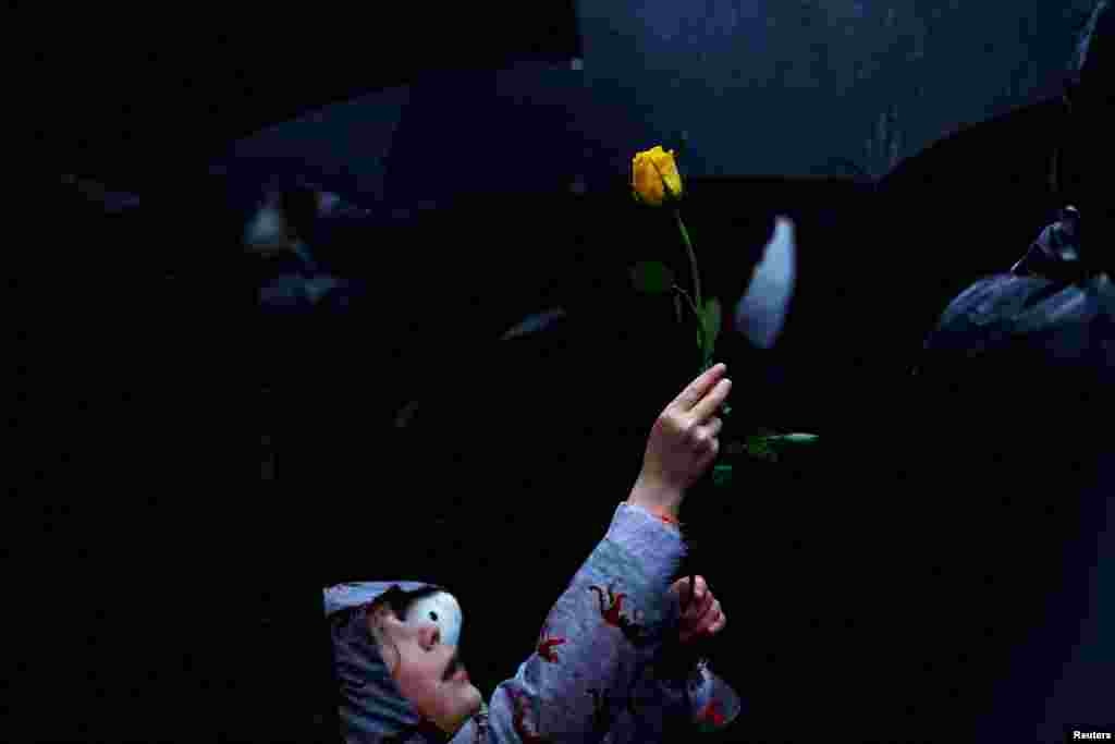 Octavia Jeram, 6, holds up a yellow rose during a vigil outside Downing Street in London, in solidarity with Palestinians after the Al-Ahli hospital blast in Gaza, Oct. 18, 2023.