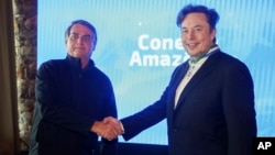 FILE - In this handout photo provided by the Ministry of Communication, Brazil's then-President Jair Bolsonaro, left, and Tesla and SpaceX chief executive officer Elon Musk shake hands during a meeting in Porto Feliz, Brazil, May 20, 2022.