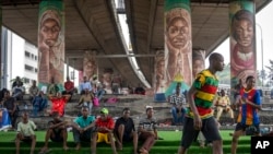 People watch as youth play football underneath a highway bridge on Ikoyi Island, Lagos, Nigeria, Feb. 23, 2023.
