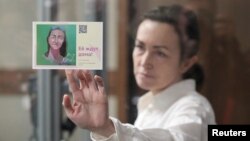 (FILE) Russian-American journalist Alsu Kurmasheva for Radio Free Europe/Radio Liberty, who is in custody, holds a card reading "She's expected home," April 1, 2024.