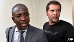 FILE —Guy Herve Kam, lawyer of the ''Balai Citoyen'' movement stands next to spokesperson of 'the group Serge Martin Bambara Smockey (R), during negotiations on the transitional government in Burkina Faso, on November 12, 2014 in Ouagadougou.