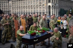 Soldiers pay their last respects at the coffin of Ukrainian serviceman Sergiy Yarmolenko, who was killed in a battle with Russian troops, during his funeral in Independence Square in Kyiv, Sept. 14, 2023.