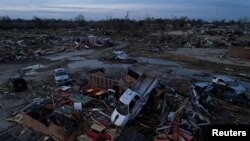 Sebuah truk pickup terlempar ke atas puing-puing bangunan kafe setelah badai yang berubah menjadi tornado menyapu Kota Rolling Fork di negara bagian Mississippi, Minggu, 26 Maret 2023. (Foto: Cheney Orr/Reuters)