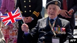 D-Day veteran Joe Randall waves a Union flag as he waits to meet King Charles, following the UK's national commemorative event to mark the 80th anniversary of D-Day, in Southsea Common, southern England, on June 5, 2024.