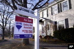FILE - A sign announcing a house for sale is posted outside a single family home, in Exeter, New Hampshire, Feb. 7, 2023.