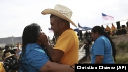 Personas que viven en Estados Unidos abrazan a parientes y amigos que radican en México durante el 10mo evento anual "Abrazos, no muros", en la franja del Río Bravo, en Ciudad Juárez, México, el sábado 6 de mayo de 2023. 