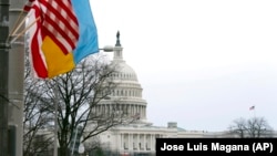 Zgrada Capitla, fotografisana uz zastave SAD, Ukrajine i Washingtona, pred govor o stanju nacije predsjednika Joea Bidena 1. marta 2022. godine. (AP/Jose Luis Magana)