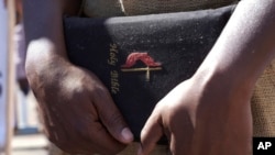 A member of the United Methodist Church in Zimbabwe holds a Bible while protesting at the church premises in Harare, May 30, 2024.