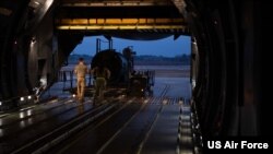 FILE - Airmen assigned to the 437th Aerial Port Squadron, load equipment bound for Ukraine onto a C-5 Super Galaxy at Joint Base Charleston, South Carolina, Jan. 31, 2023.