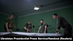 Ukraine's President Volodymyr Zelenskiy listens a report of Commander of the Ground Forces colonel general Oleksandr Syrskyi at a position near the front line in Donetsk region, June 26, 2023. 