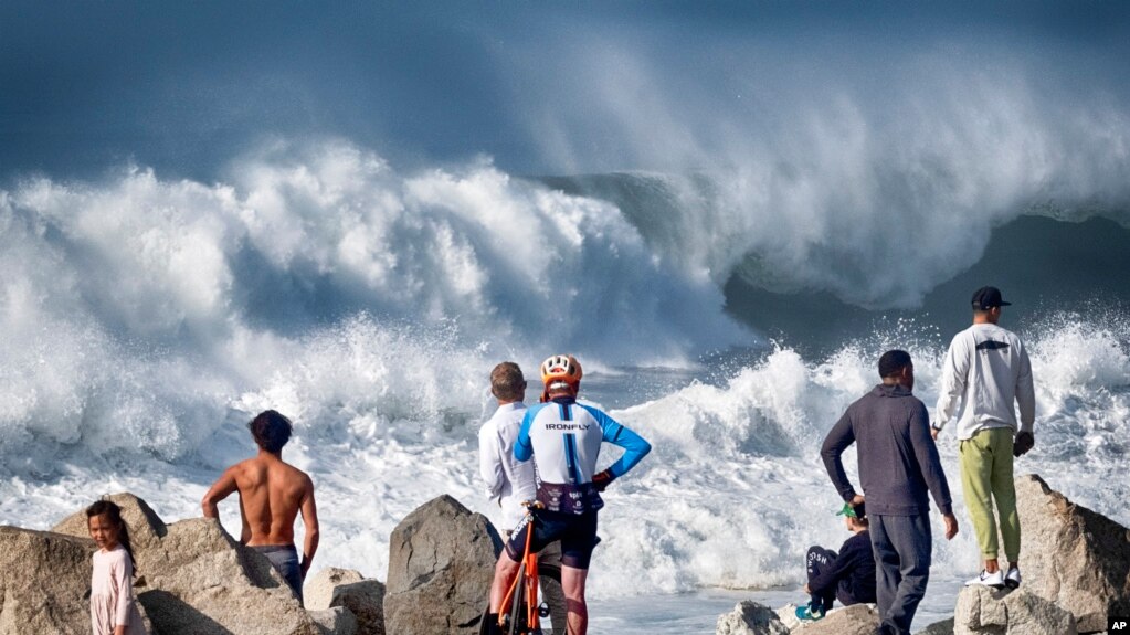 2023年12月28日，在加利福尼亚州曼哈顿海滩，海滩上的游客观看湍急的海浪冲击着曼哈顿海滩的海岸。（美联社照片）(photo:VOA)