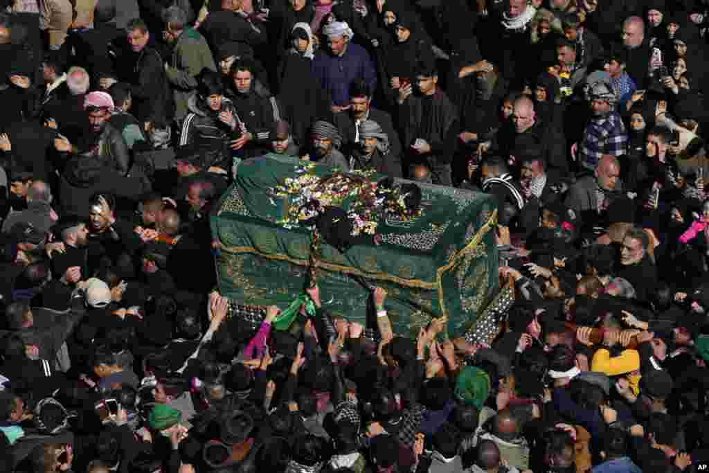 Shiite worshippers carry a symbolic coffin at the golden-domed shrine of Imam Moussa al-Kadhim, who died at the end of the 8th century, during the annual commemoration of his death in Baghdad, Iraq.