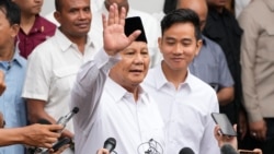 Menteri Pertahanan Indonesia dan presiden terpilih Prabowo Subianto (kiri tengah), melambaikan tangannya didampingi pasangannya, Gibran Rakabuming Raka (kanan tengah), di Gedung Komisi Pemilihan Umum di Jakarta, Rabu, 24 April 2024. (AP/Achmad Ibrahim)