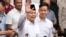 Menteri Pertahanan Indonesia dan presiden terpilih Prabowo Subianto (kiri tengah), melambaikan tangannya didampingi pasangannya, Gibran Rakabuming Raka (kanan tengah), di Gedung Komisi Pemilihan Umum di Jakarta, Rabu, 24 April 2024. (AP/Achmad Ibrahim)