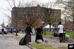 People clean up debris at the scene of a shooting at an Eid al-Fitr event in Philadelphia, a city in the U.S. state of Pennsylvania, April 10, 2024.