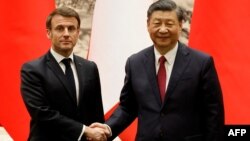 Presiden China Xi Jinping (kanan) berjabat tangan dengan Presiden Prancis Emmanuel Macron setelah upacara penandatanganan di Beijing pada 6 April 2023. (Foto: AFP/Ludovic MARIN)