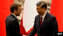 China's President Xi Jinping shakes hands with his French counterpart Emmanuel Macron after a signing ceremony in Beijing, April 6, 2023. 
