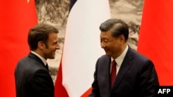 China's President Xi Jinping (R) shakes hands with his French counterpart Emmanuel Macron after the signing ceremony in Beijing on Apr. 6, 2023. 